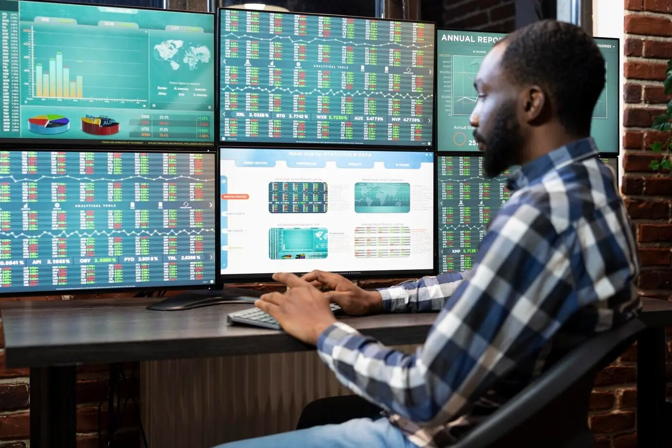 Чернокожий мужчина работает за трейдинговым столом